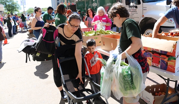 Maricela receives bags of produce from a FRESH Truck volunteer