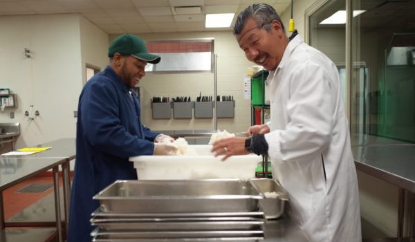 A Chicago's Community Kitchens student prepares food with Chef Bill Kim