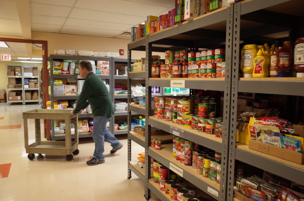 A volunteer moves food on a cart at Wheeling Township Food Pantry