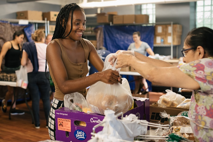 Alexus Watkins receives food from a volunteer.