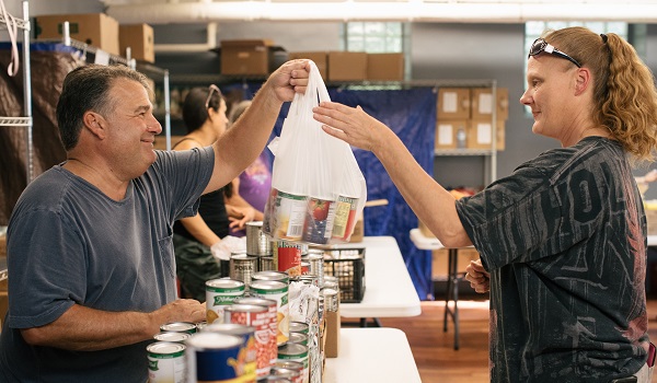Volunteer serves a client at the Christian Life Center food pantry in Berwyn.