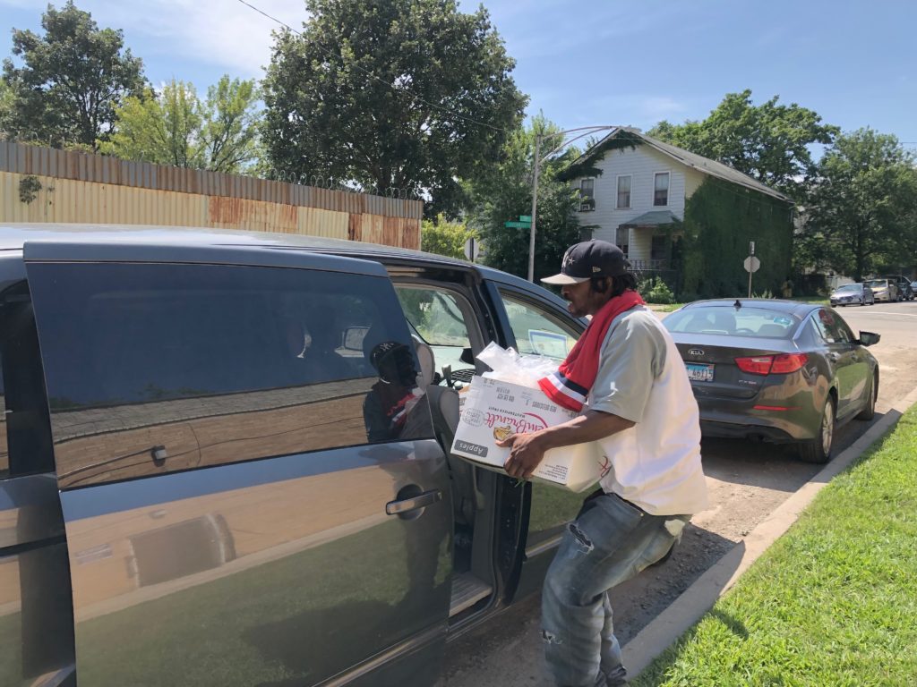 Shawn Hopkins, 34, puts food he received from the New Life Covenant Southeast food pantry into a car