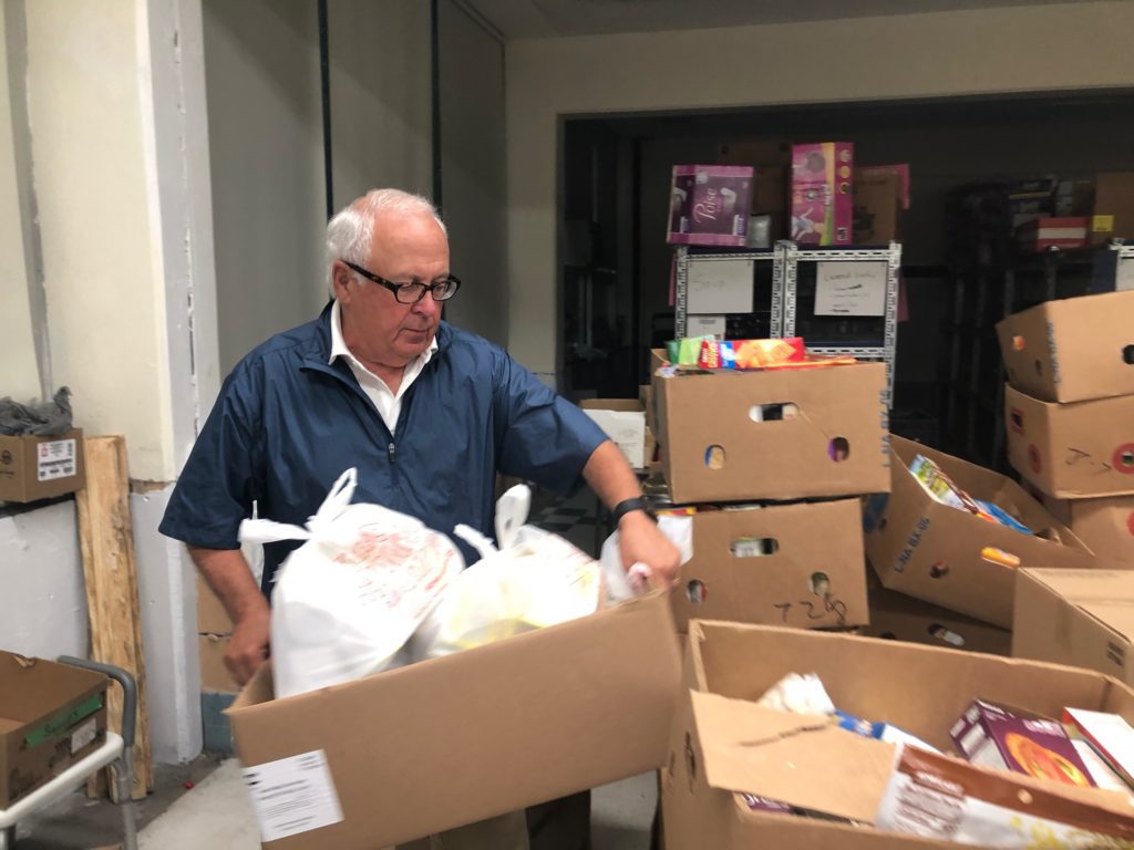 Volunteer Dan Roth, 70, moves bags of cereal in the remodeled storage space in the Mission of Our Lady of the Angels old school building. 