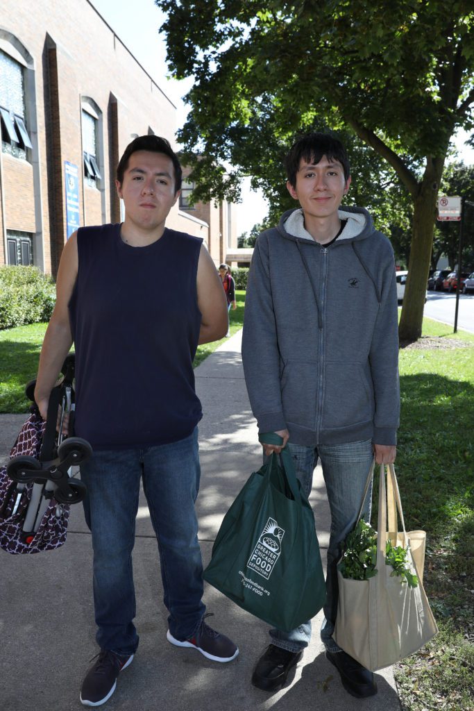 Eric and Edwin Arteaga, ages 22 and 21, pick up fresh produce for their family. 