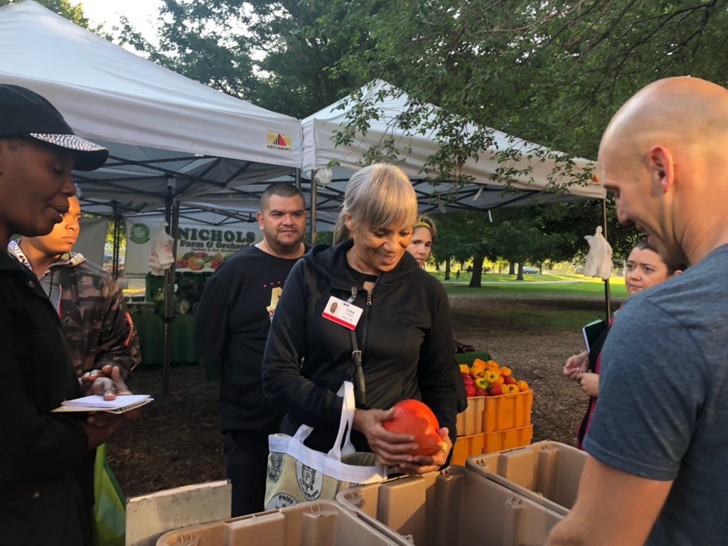 Lisa Colbert examines a gourd from Nichols Farm at the Green City Market in Lincoln Park with farm employee Steve Freeman