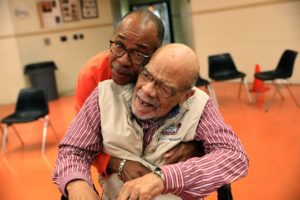 The Rev. Rodney Walker hugs Corwin Marbly, Sr.