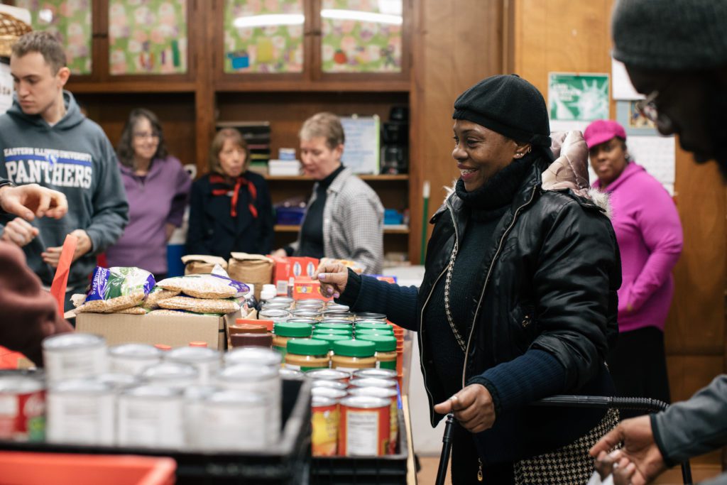 Ava Mitchell receives food from the volunteers at the St. Ignatius pantry in Rogers Park