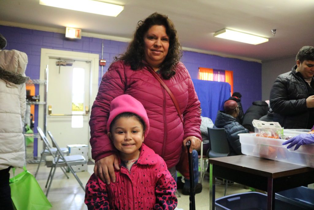 Maria Ruiz and her four-year-old daughter, Emely, pose for a photo during the distribution at the Hattie B. Williams food pantry