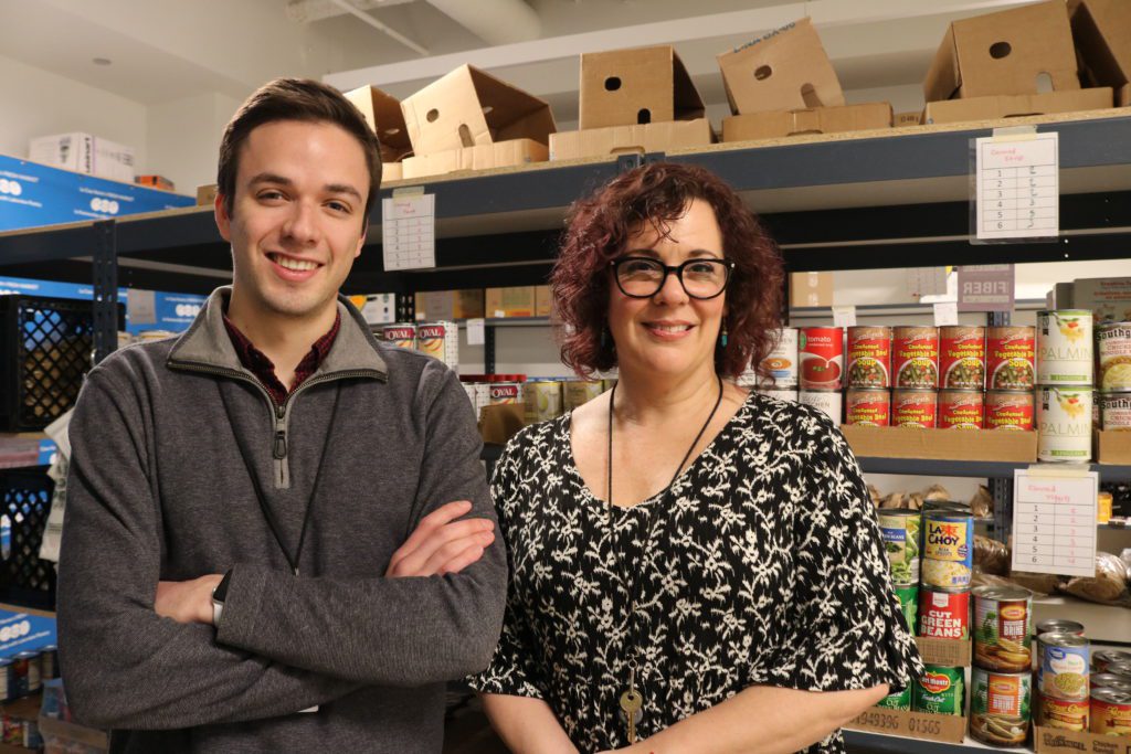 AmeriCorps VISTA member Ryan Maia (left) and La Casa Norte's community engagement coordinator Rebecca Sumner Burgos pose inside La Casa Norte's food pantry.