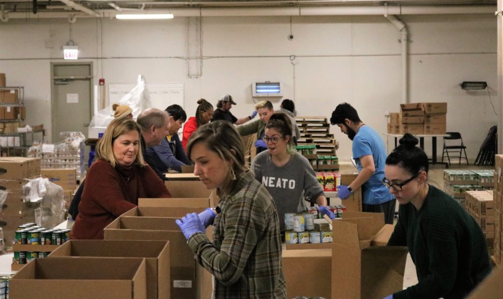 Volunteers pack boxes of shelf-stable food in the Greater Chicago Food Depository warehouse