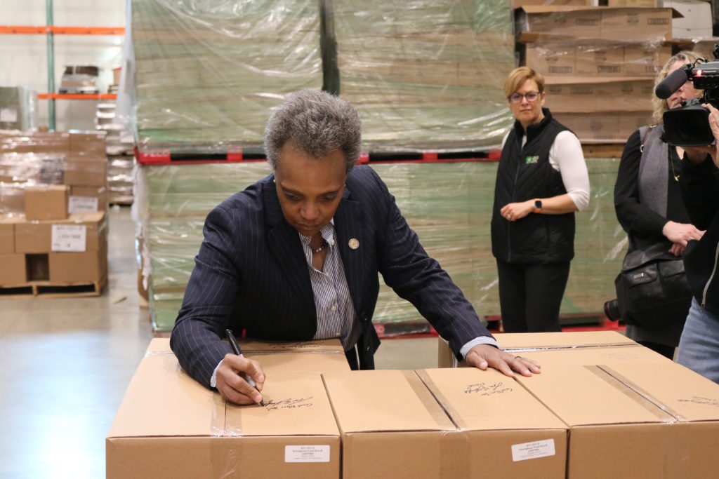 Mayor Lori Lightfoot signs food boxes to be sent to families across Cook County