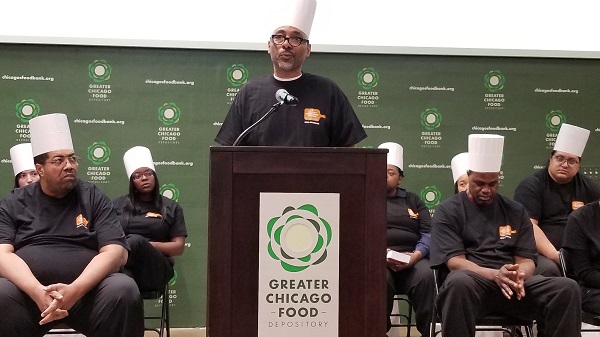 Demetrius Newman addresses the audience during the Chicago's Community Kitchens graduation.