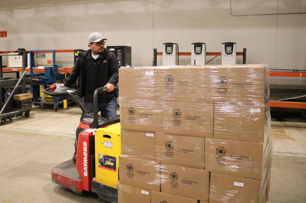 Jose DeSantiago fills a Food Depository truck with non-perishable food boxes to be stored at the United Center
