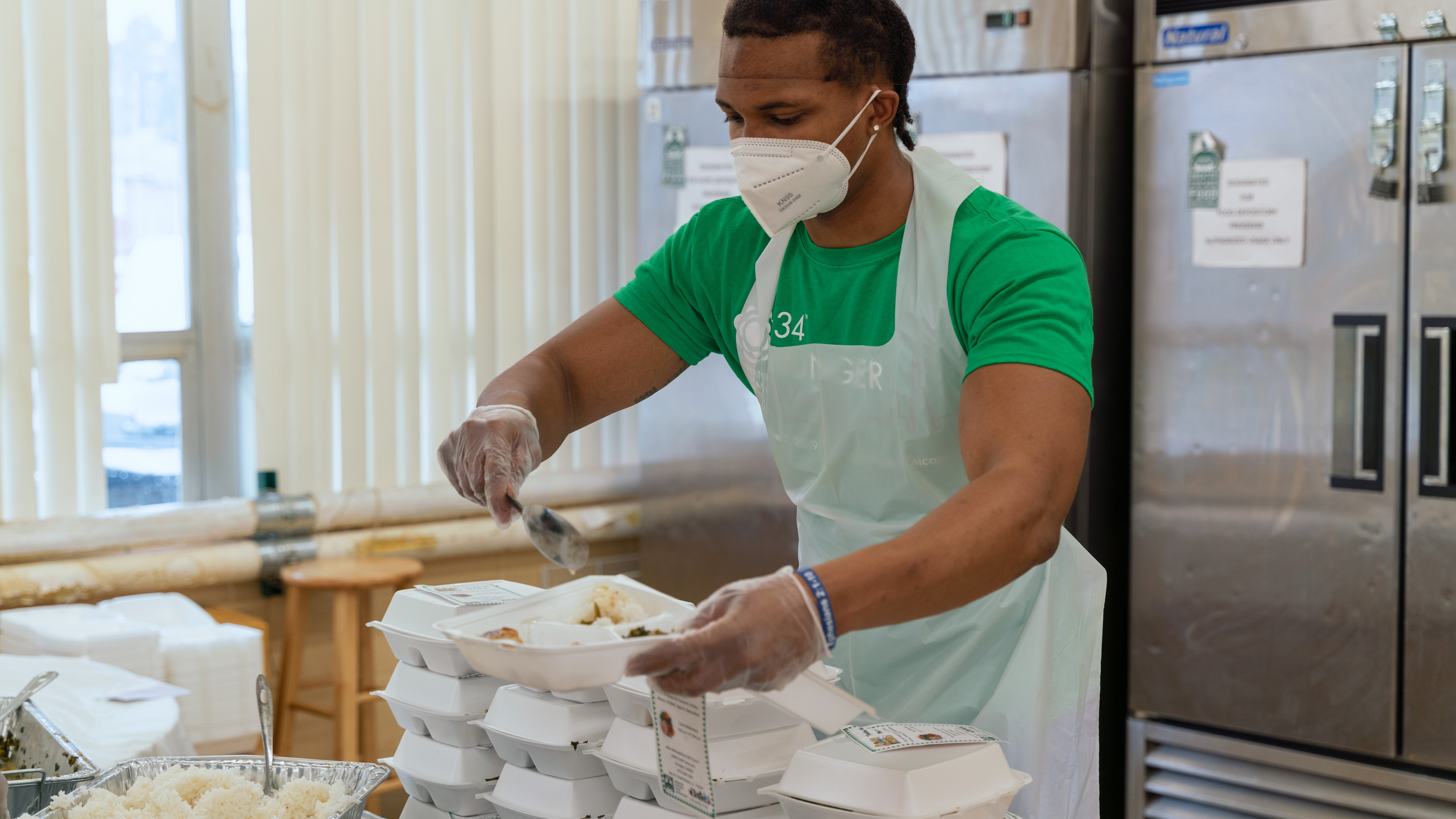 A volunteer packs meals into to-go containers at Allen Metropolitan Church