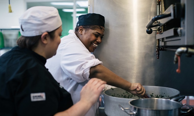 A student in Chicago's Community Kitchens stirs a pot of food