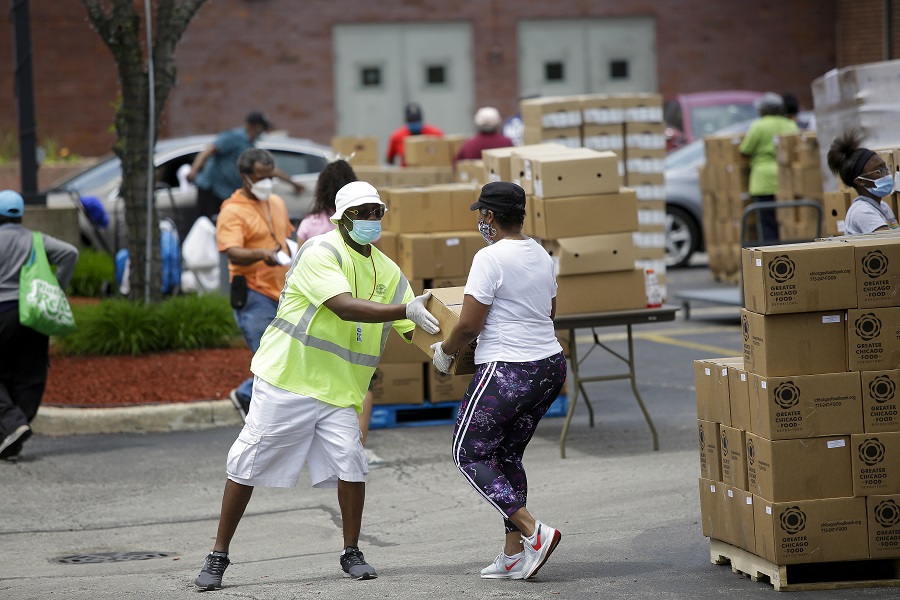 Volunteers help residents effected by the Coronavirus (COVID-19) outbreak as they help distribute food donated by the Greater Chicago Food Depository at the Apostolic Church in the Woodlawn neighborhood on Friday, May 26, 2020 in Chicago, Illinois. Photo by Joshua Lott for GCFD