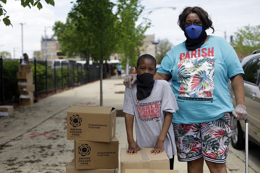 Cynthia Nobles, pictured here with her grandson, at the Apostolic Church of God pop-up distribution in Woodlawn 