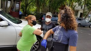 Dionne Frye, on left, of Mothers Against Street Shooters exchanges an elbow bump with Cecile DeMello of Teamwork Englewood.