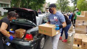 Volunteers with St. Bernard Hospital load boxes of food into a car at the Englewood pop-up.