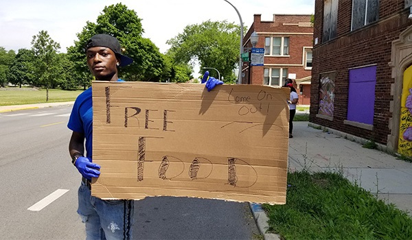 A volunteer with Teamwork Englewood tries to get the attention of passersby on Racine Avenue.