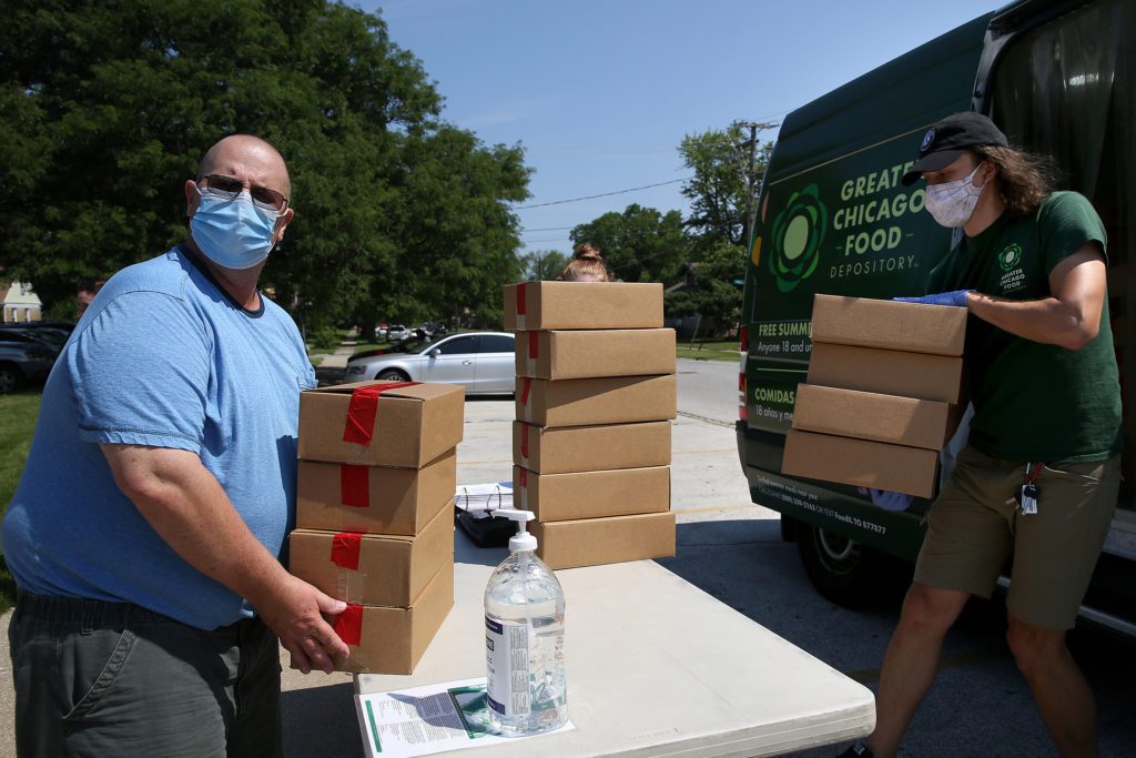 Harry Carey picks up meals for his children at the Lansing Lunch Bus stop