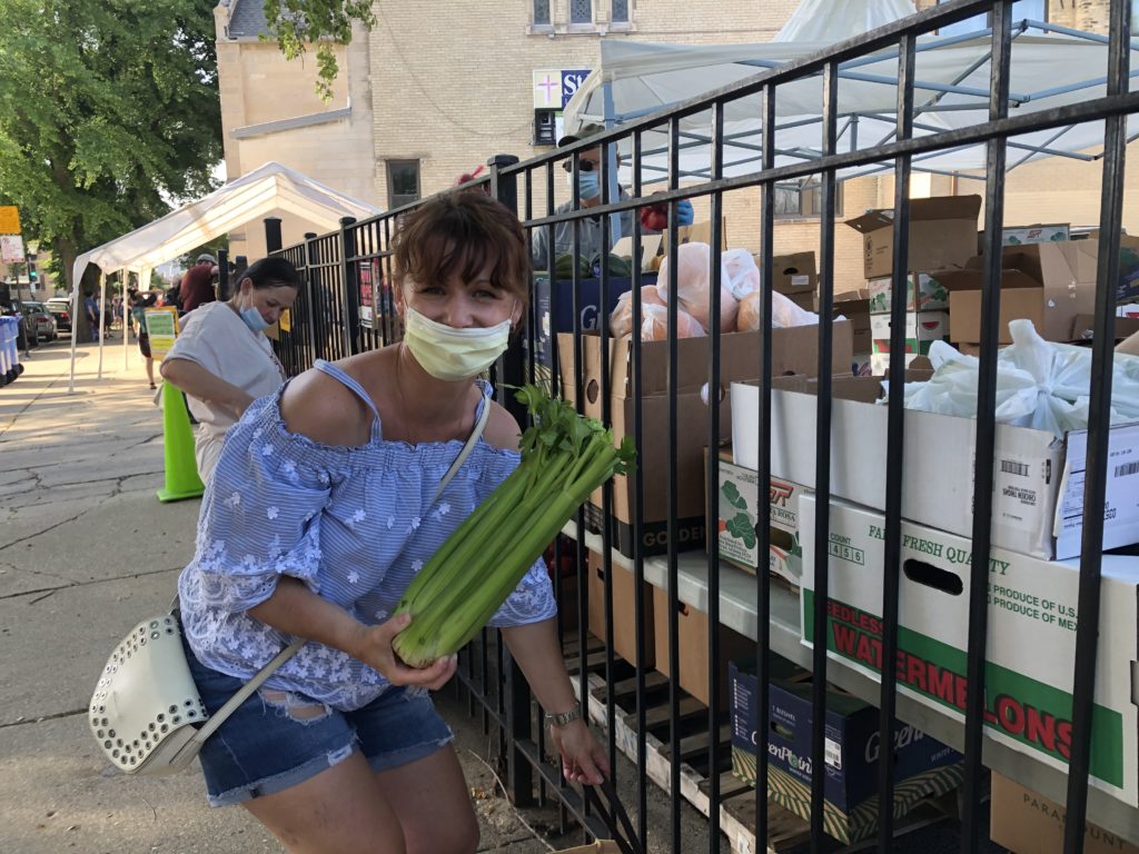 Dominika Bolkowska receives fresh produce from a volunteer at the Joined Hands pantry.