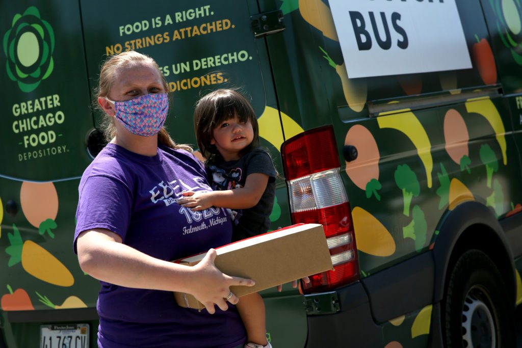 Megan Bustamante and her daughter, Esme, in front of the Lansing Lunch Bus