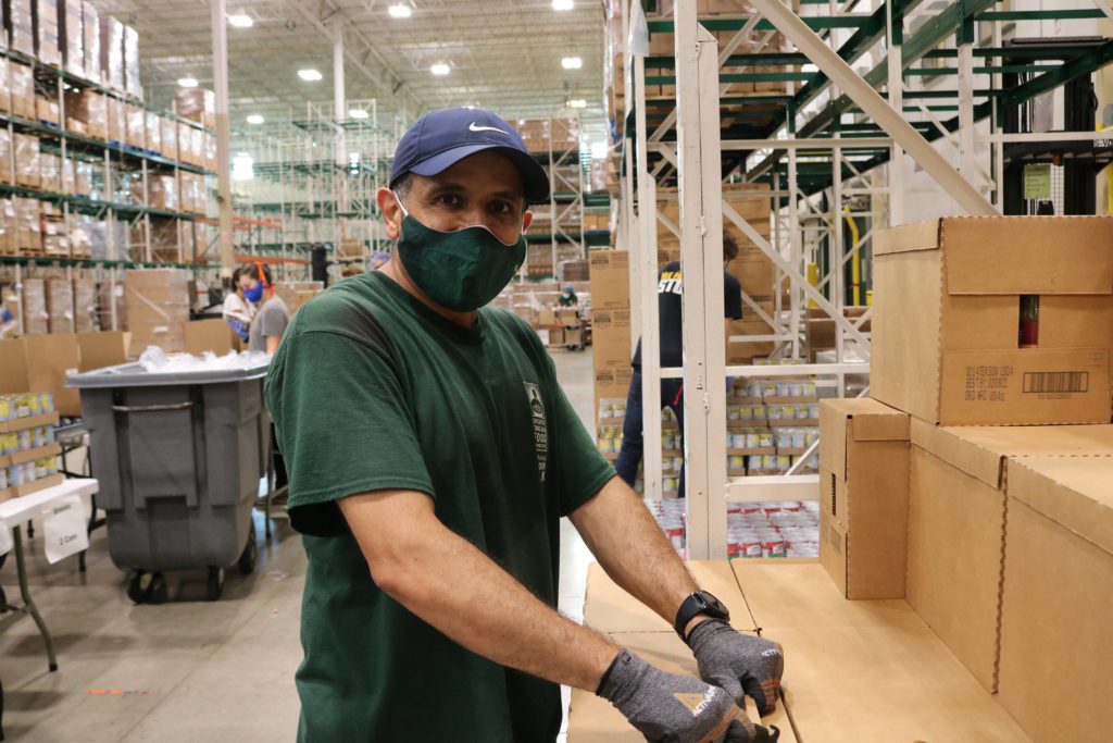 Naser Nasser helps create emergency food boxes during a volunteer session in July