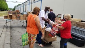 A Safe Haven volunteer places eggs into a bag for a woman at the weekly food pantry.