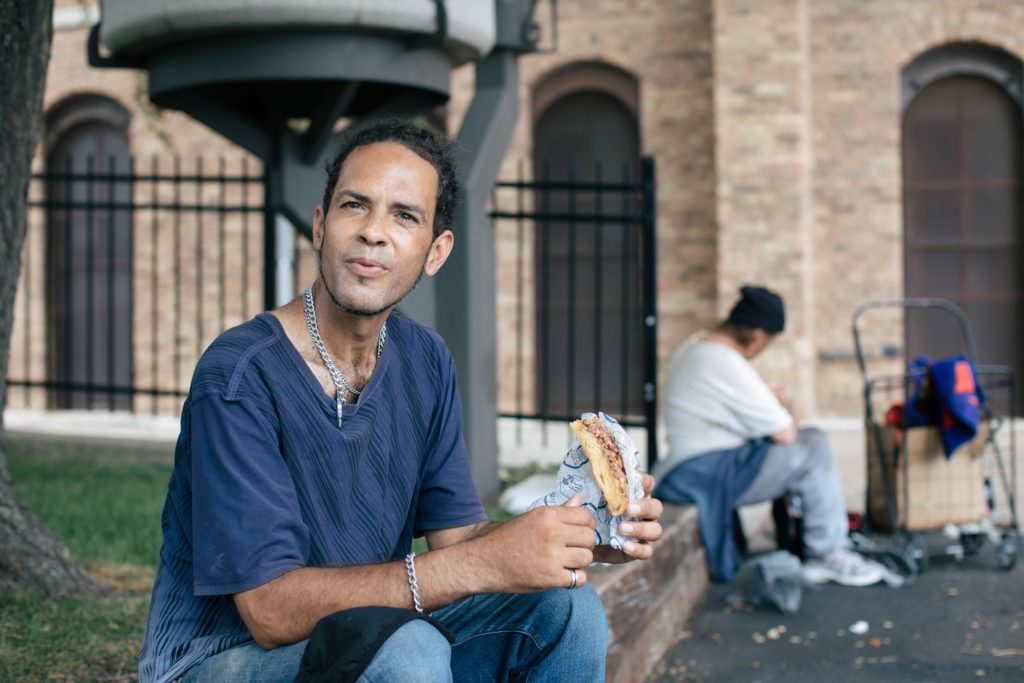 Gilberto Gonzalez eats his meal outside the St. Stanislaus Kostka Church, where the Providence Soup Kitchen serves hot meals four days a week.