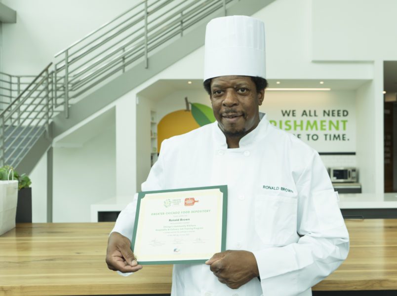 Ronald Brown receives his graduation certificate at the Food Depository headquarters