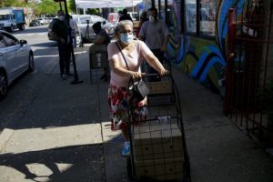 A woman leaves a food distribution in Little Village.