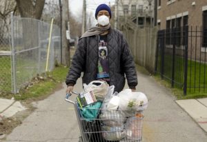 A man poses for a portrait after receiving bags of food at Chosen Tabernacle Ministries in Bronzeville.