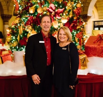 George and Cindy Rusu pose for a photo at a holiday party.
