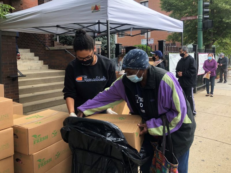 A volunteer helps a guest at the Northwestern Settlement food pantry