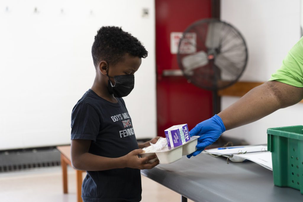 A student at the South Side YMCA receives a lunch on a recent October afternoon. 