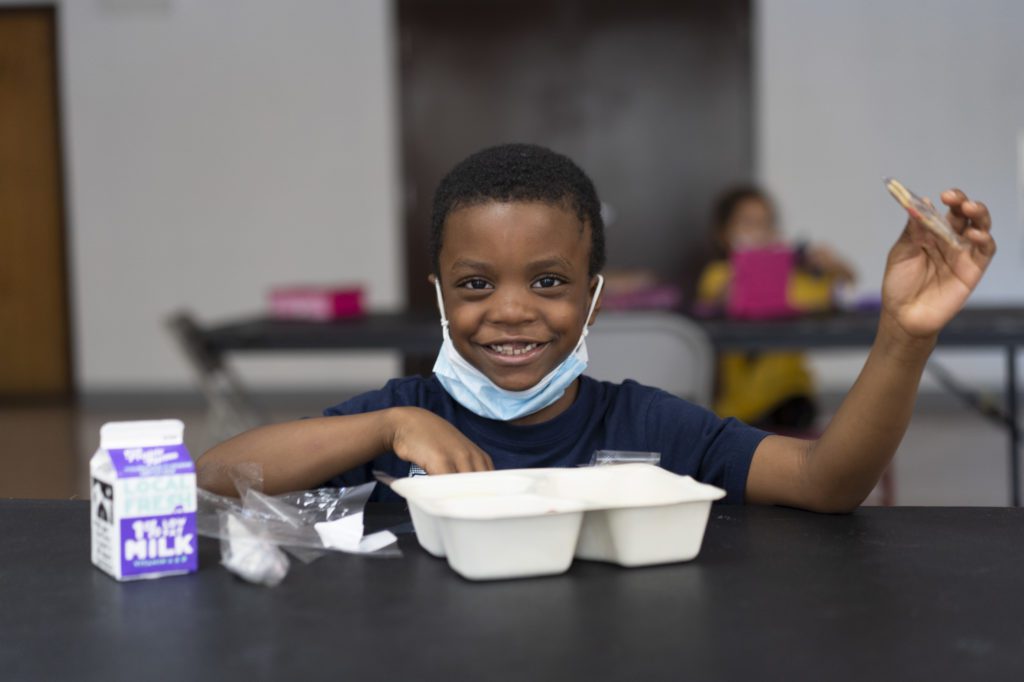 A student at the South Side YMCA eats his lunch, provided in partnership with the Food Depository. 