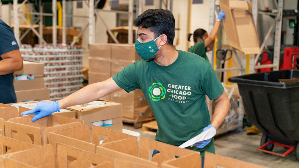 A volunteer follows safety precautions in the Food Depository warehouse
