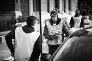 Volunteers load pies and other holiday food into a car.