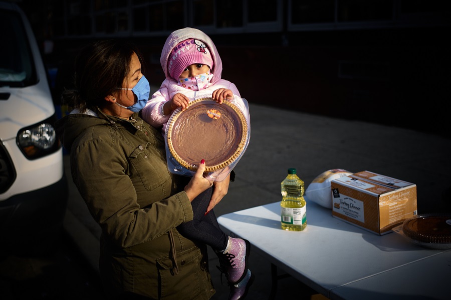 A woman and her daughter receive a pumpkin pie and other holiday food.