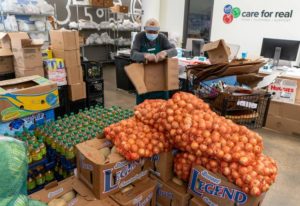 A volunteer breaks down boxes at Care for Real, which has seen a rise in need during the pandemic.