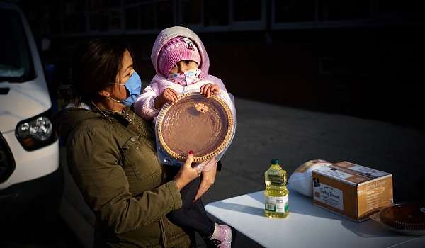 A woman and her daughter receive holiday food at Our Lady of the Angels.