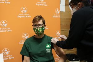 Kate Maehr, the Food Depository's executive director and CEO, receives the first dose of the COVID-19 vaccine.