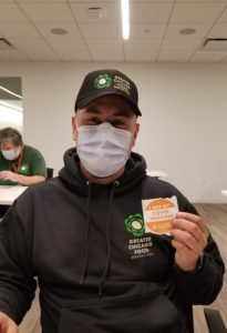 Xavier Hernandez holds his vaccine sticker after receiving his first shot.