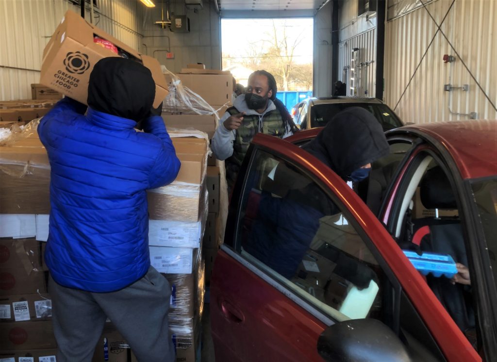 Workers at the Thornton Township food pantry pack cars with food