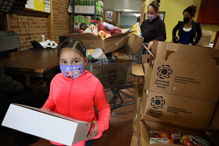 A girl and her mother receive food at the Blue Cap pantry.