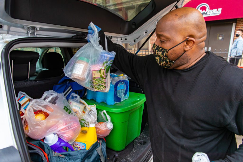 Volunteer Corry Holman fills up a car at the Circle Urban Ministries' Daily Bread food pantry