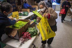 Cecilia Avalos placing fresh groceries in her bag.