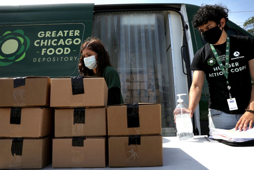 Hunger Action Corps members Melissa Lopez-Gomez (left) and Andres Ricon pass out meals on the West Suburban Lunch Bus route. 