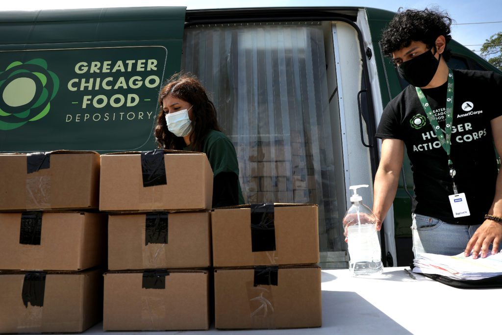 Hunger Action Corps members Melissa Lopez-Gomez (left) and Andres Ricon pass out meals on the West Suburban Lunch Bus route. 